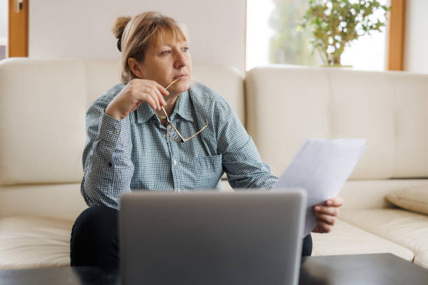 istock Active mature woman using a laptop for remote work from the home office. Video conference, video meeting. Senior teacher leads webinar 1440763181