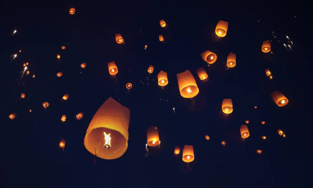 lassen sie die traditionellen papierlaternen in der nacht des festivals in thailand in den himmel steigen. - releasing stock-fotos und bilder