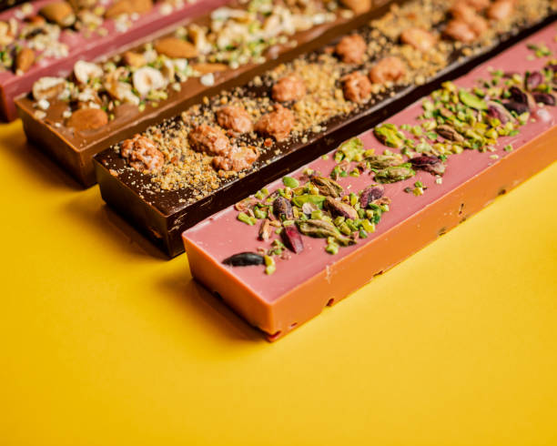 istock Closeup of chocolate assortment bars with different flavors on a yellow surface 1440763696