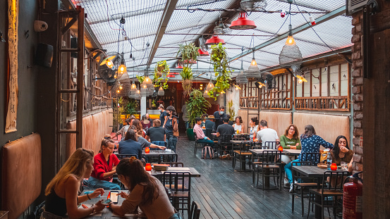 Porto, Portugal – July 05, 2021: A shot of the interior of Asian restaurant Boa-Bao with all tables being filled in Porto.