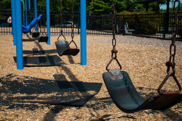 istock Multiple Swings hang still without children to play on them at a 1440766018
