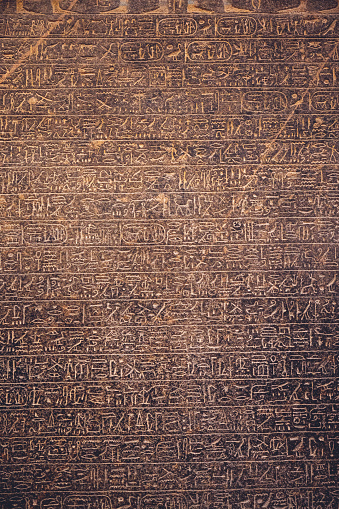 Cairo, Egypt – June 06, 2021: A vertical shot of Egyptian hieroglyphs covering an ancient stone surface in the Egyptian Museum in Cair