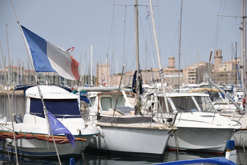 A closeup view of boats in the harbor with the French flag in front in France