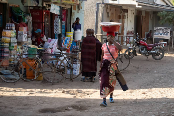 Portrait of a young African woman with headscarf and a basket with fruit on her head. Rwanda