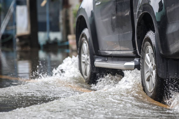 istock Black pickup truck driven through a flooded road 1440768784