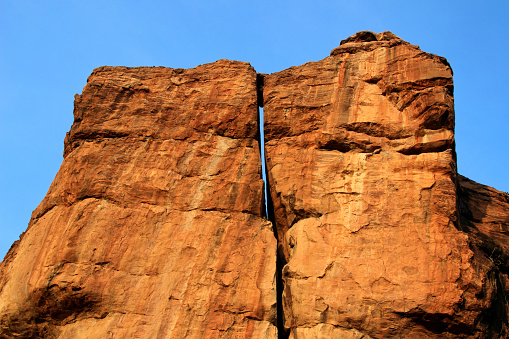 Huge rock surfaces soaked in the morning sunlight with rich blue sky at Badami, Karnataka, India