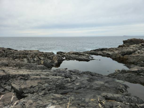istock Beautiful shot of rough rocky cliffs by the beach under a cloudy sky 1440771747
