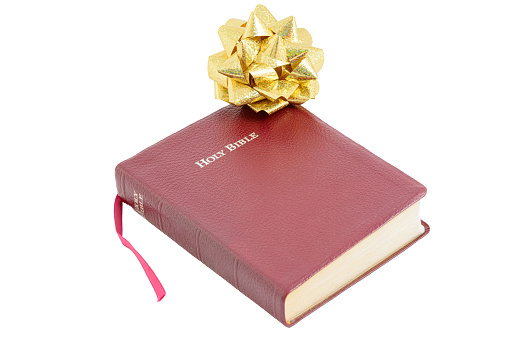 Bible with ribbon as a gift on a white background