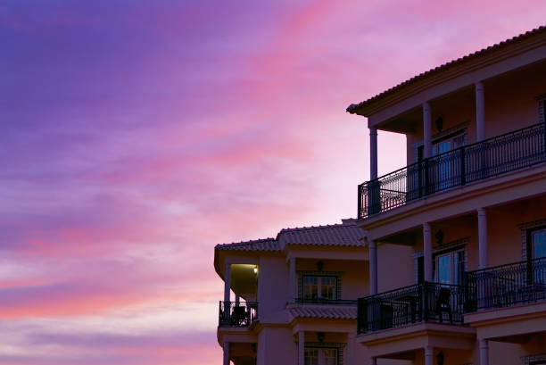 A building with balconies under the beautiful pink sunset sky