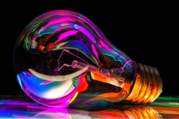istock Light bulb with colorful lights reflecting in it 1440773476