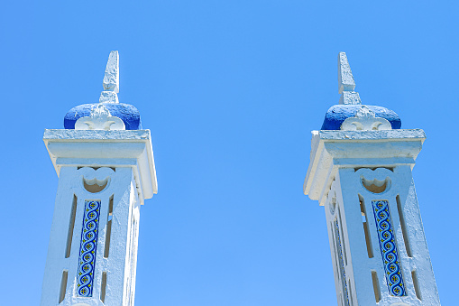 Two painted rectangle pillars on a blue background in Benidorm, Spain