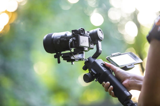 istock A girl operating camera mounted on a gimbal, focus on the gimbal and camera. 1440775094