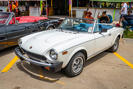 Des Moines, IA - July 02, 2022: High perspective front corner view of a 1979 Fiat 124 Spider 2000 Convertible at a local car show.
