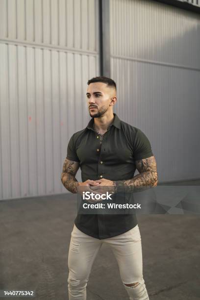 Hot Caucasian Man With Arm Tattoos In An Emerald Green Shirt And White  Pants Posing In The Street Stock Photo - Download Image Now - iStock