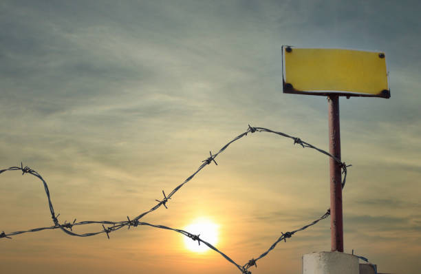 istock Closeup shot of barbed wire on a post with copy space during sunset 1440775513
