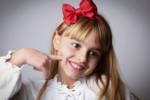 Cute smiling girl. She is against white background.