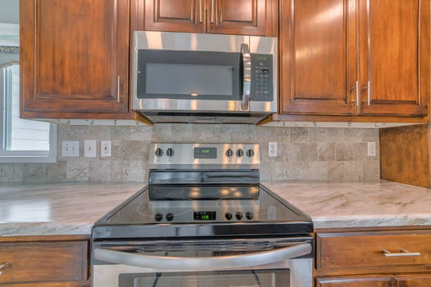 istock Tiled wall kitchen setup with wooden shelves, cooking equipment 1440776696