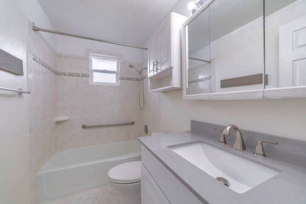 istock Mirror, a sink, and a bath with a closed transparent curtain in a bathroom 1440777442