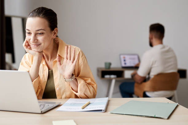 istock Young smiling student waving hand to tutor during online lesson or webinar 1440777523
