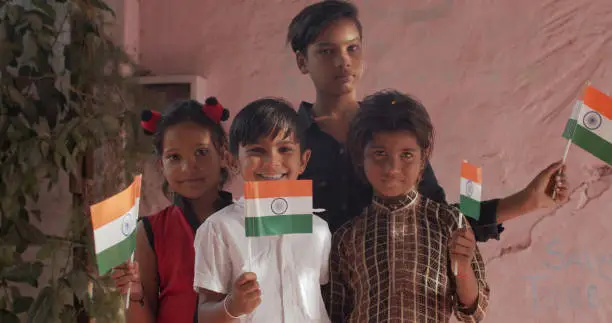 Photo of Group of South Asian children posing with Indian flags