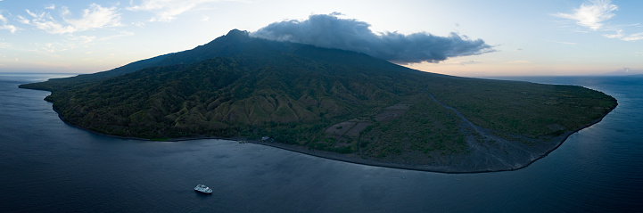 The sun rises behind the beautiful volcano of Sangeang, found just outside of Komodo National Park, Indonesia. The reefs and black sands that surround the island support a wide variety of marine life.
