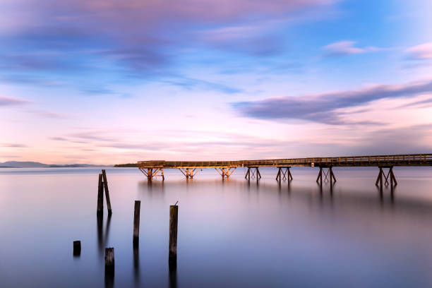 istock Long pier stretching out at a misty ocean at sunset 1440779522