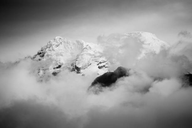 istock Grayscale shot of mountains covered in snow and clouds 1440780580