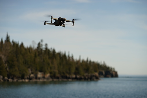 Thunderbay, Canada – May 16, 2021: A DJI air 2s drone photography over the lake with trees in the blurry background