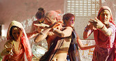 Group of females with painted faces and clothes are dancing at Holi, Festival of Colors