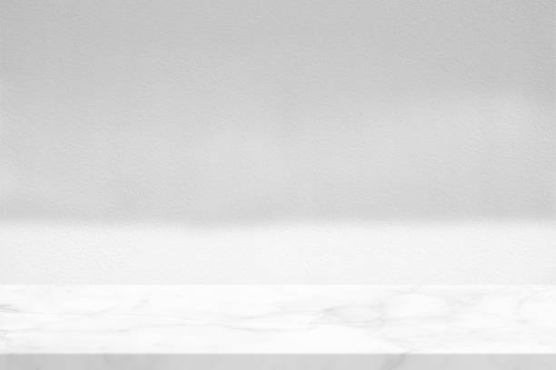 istock White Marble Table with LIght and Shadow on Concrete Wall Texture Background, Suitable for Product Presentation Backdrop, Display, and Mock up. 1440781419