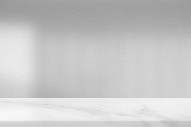 istock White Marble Table with Light and Shadow from Window on Concrete Wall Texture Background, Suitable for Product Presentation Backdrop, Display, and Mock up. 1440781445