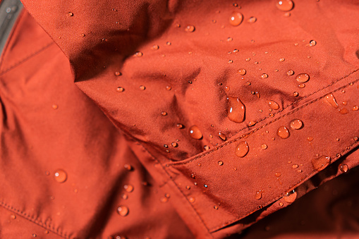 Detail photo of wateproof jacket with water droplets on it. Gore-tex jacket in detail.