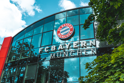 Munich, Germany – August 03, 2021: A low angle shot of the FC Bayern Munich headquarters on a bright summer day with lush trees around it