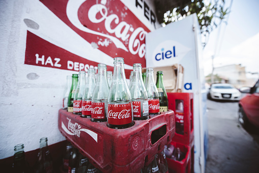Zacatecas, Mexico – April 01, 2018: A set of half-empty Coca-Cola glass bottles in a red Coca-Cola box