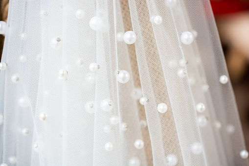A closeup shot of a bride veil enveloped in pearls