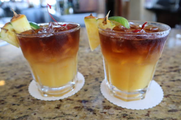Pair of mai tai cocktail beverages with pineapple garnish at a bar in Kona, Hawaii A pair of mai tai cocktail beverages with pineapple garnish at a bar in Kona, Hawaii mai tai hawaii stock pictures, royalty-free photos & images