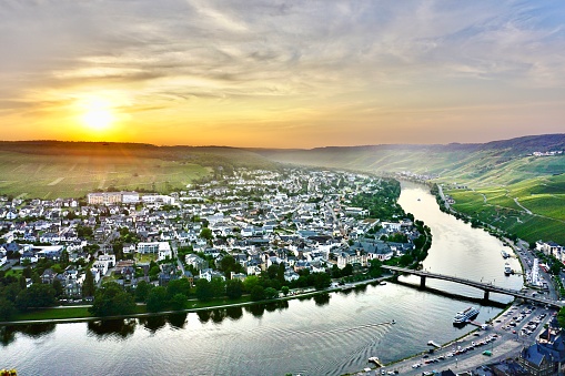 Sunset on the Moselle River. The winding silat of the river at sunset. The curved Moselle River at sunset. Vineyards on the slopes of the Moselle River at sunset.