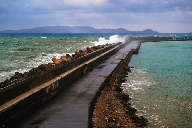 Pier in Heraklion, stormy sea and splashing water on stone and road. stock photo