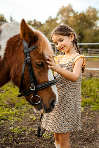 Happy young girl riding her horse outdoors