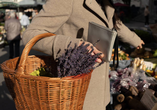 kobieta trzyma w rękach torebkę i kosz lawendy i wskazuje produkt, który chce kupić - lavender lavender coloured flower herb zdjęcia i obrazy z banku zdjęć