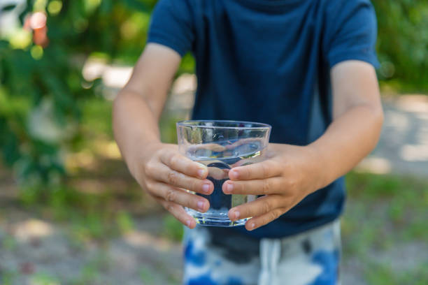 istock The child drinks water from a glass. Selective focus. 1440790655
