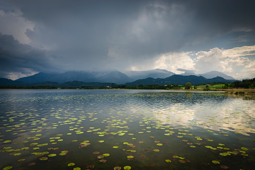 Thunderstorm clouds over the tranquil Lake Hopfen and the Tannheim Mountains of the European Alps, Allgäu, Bavaria, Germany