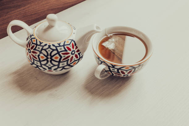Cup of tea and teapot with colorful geometric patterns