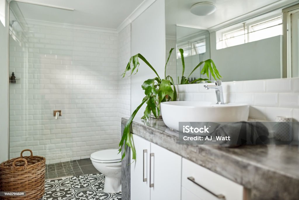 Bathroom interior of contemporary home Small bathroom with sink, toilet bowl and wicker laundry bag along the shower area in contemporary home Bathroom Stock Photo