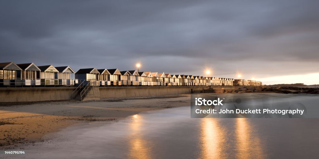 Beach huts at Southwold in Suffolk Dark, moody and stormy long exposure photograph of the beach huts near the pier at Southwold on the Suffolk coast Southwold Stock Photo