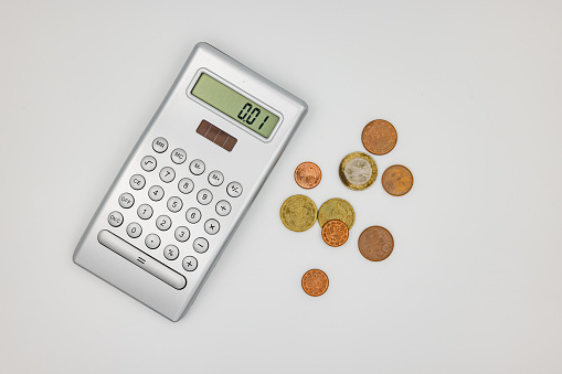 Studio shot of a calculator with euro and cent coins as a sign of poverty in the energy crisis