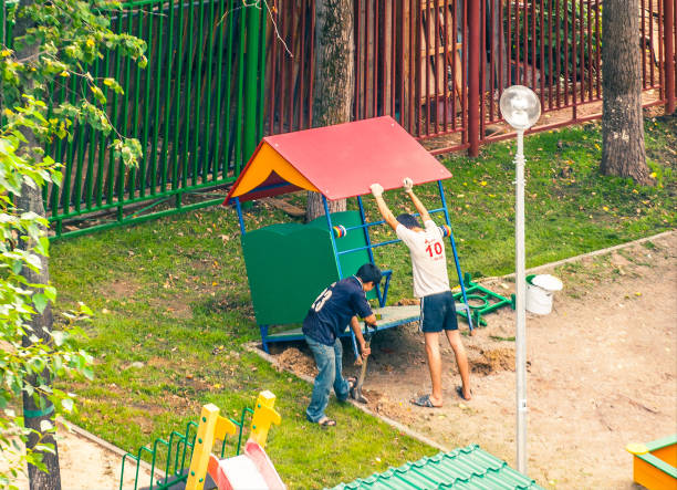 Moscow, Russia - july 10, 2013: Young asian guest workers working on the kindergarten playground