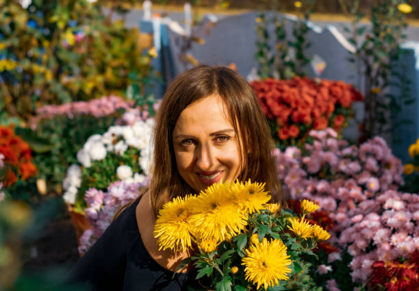 istock A woman crouched in a flower bed with chrysanthemums. 1440799256