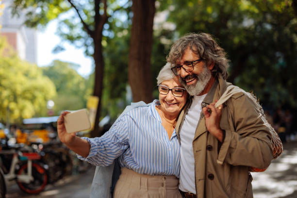 Senior couple videocall in street.