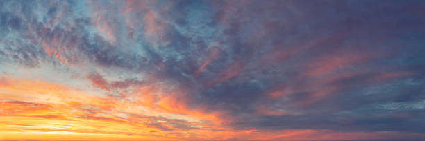istock Panoramic skyscape with vibrant sunlit clouds at sunset 1440800045